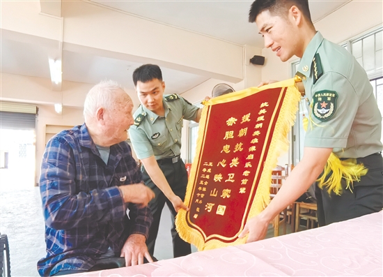 部队官兵代表向谭启乐送上锦旗。