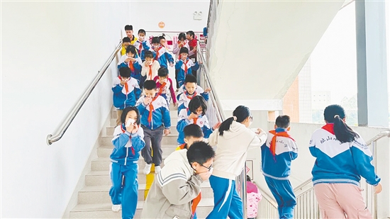 演练中,学生们弯腰低姿、用湿毛巾捂住口鼻,按照预设疏散路线快速向安全区域撤离。 演练中,学生们弯腰低姿、用湿毛巾捂住口鼻,按照预设疏散路线快速向安全区域撤离。