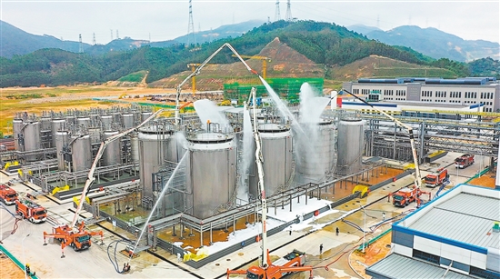 演练现场，举高喷射消防车凭借五节折叠臂架升至62米高空，精准打击火情。