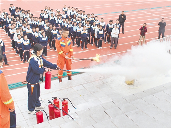 学生参与实操练习,利用灭火器灭火。 学生参与实操练习,利用灭火器灭火。