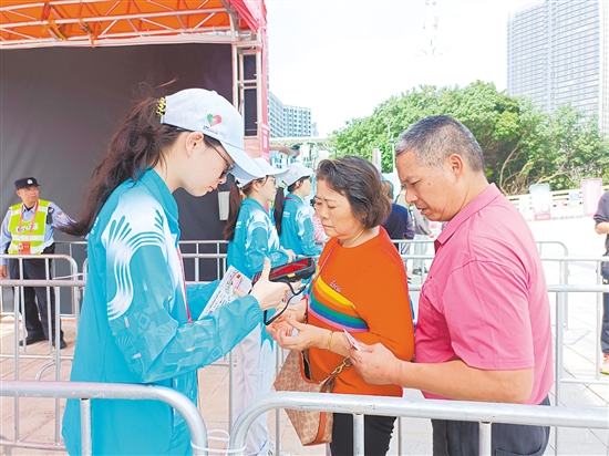 志愿者在场馆外为观众检票。