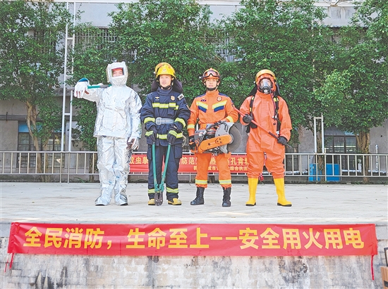 消防员展示各类消防服，宣传安全用火用电理念。