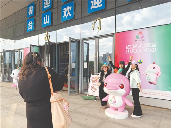 众多湾区游客组团来到台山看比赛、品美食。图为游客在比赛场馆前拍照留念。