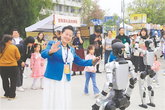 在“乐业五邑”创业创新大赛现场,华文媒体记者代表与人形机器人互动。 在“乐业五邑”创业创新大赛现场,华文媒体记者代表与人形机器人互动。