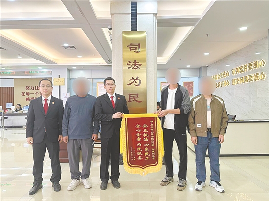 工人领到工资后,为法官团队送来锦旗致谢。