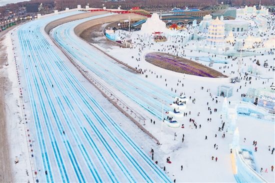 图为当日，游客在哈尔滨冰雪大世界园区体验“超级冰滑梯”（无人机照片）。新华社发