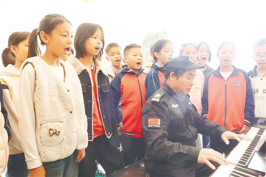 良山小学的保安陆木养弹奏钢琴，学生们随着旋律欢快唱歌。