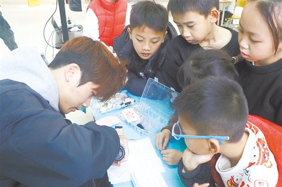 五邑大学学生为“小设计师”们提供指导。