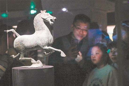 图为当天，在甘肃省博物馆二楼丝绸之路文明展厅，观众观看铜奔马（复制品）。