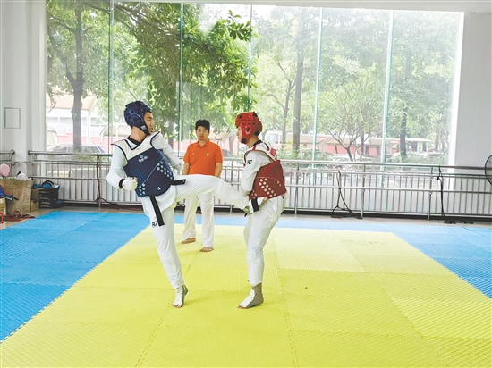 胡健（蓝色）在跆拳道训练中。