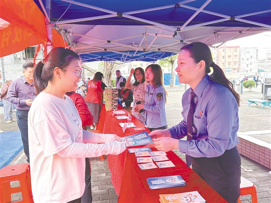 江门市检察院检察官向居民派发防范电信网络诈骗宣传资料。