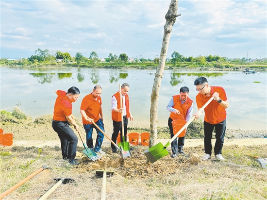干部群众挥锹培土、扶苗浇水。