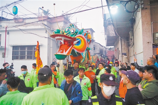 村民们高举金龙,穿街过巷进行巡游。 村民们高举金龙,穿街过巷进行巡游。