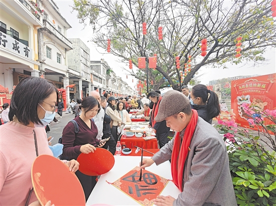 书画家现场创作，将一幅幅寓意吉祥的书画作品赠予市民游客。江门日报记者