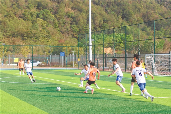 足球场上的球员精神抖擞，双方队伍互有攻防，为观众献上激情澎湃的草根足球盛宴。