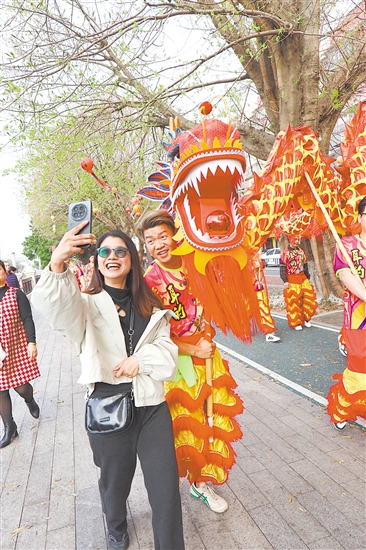 春节期间，江南路金龙巡游，吸引市民驻足合影。