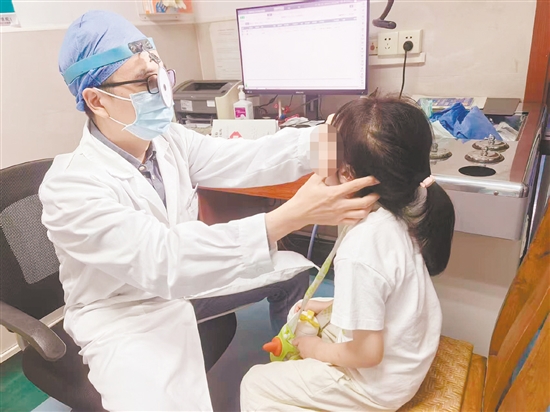 金鹏为患儿进行检查。