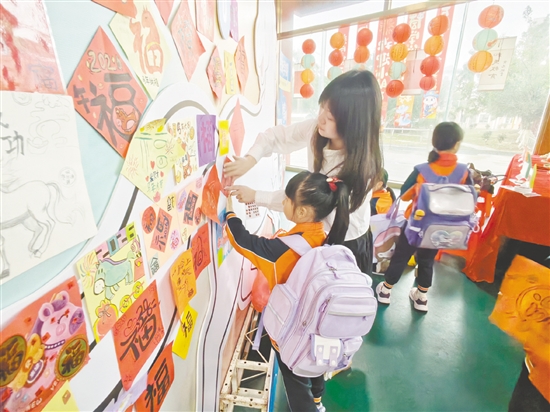 学生满怀期许地把寄托新春祝福与新学期心愿的“福”字作品张贴在学校精心准备的“马到成功”墙前。