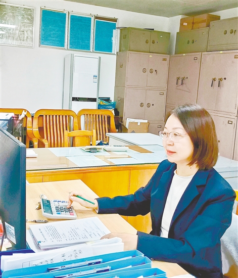吕妙芬在处理财务工作。