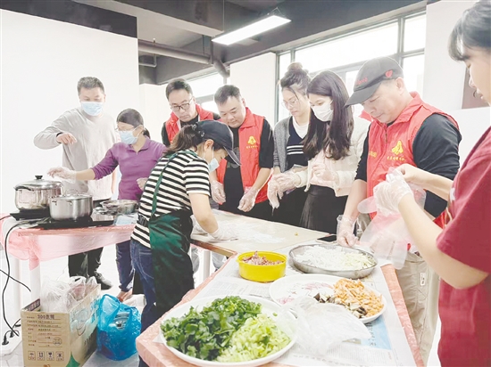 社区工作人员和志愿者们在长者饭堂一起包饺子。