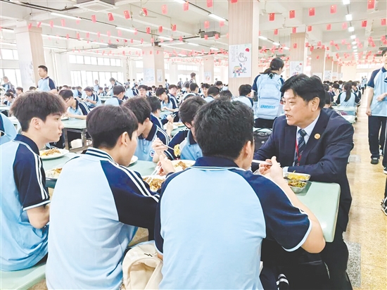 开平市第一中学校长陪餐，了解学生对食堂的建议。