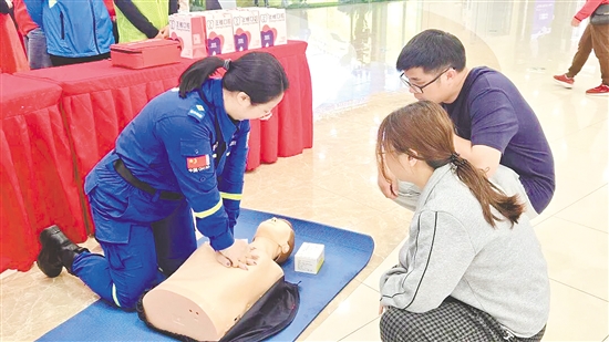 志愿者向市民示范心肺复苏等急救技能的操作要领。
