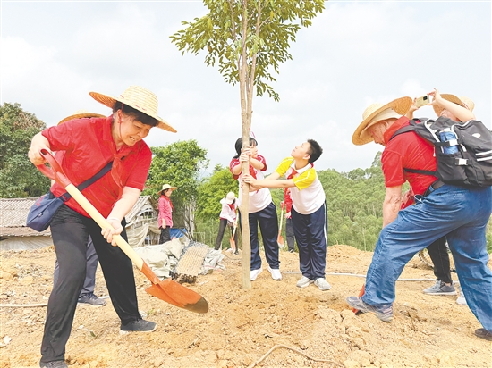 革命先辈后代与学生代表一起参加义务植树活动。