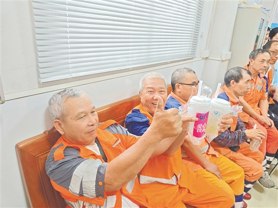 环卫工人品尝甘蔗冻茶饮后给出好评。