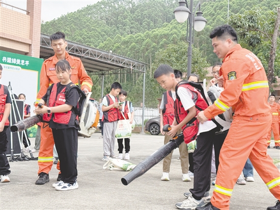 小记者体验使用背负式风力灭火机。