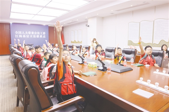 小记者们踊跃举手参与普法知识问答。