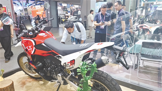 在珠峰摩托展区，外国客商认真察看企业新产品。
