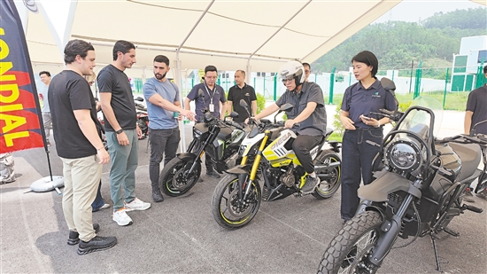 几位外商围在珠峰摩托车旁，认真打量，准备下单。
