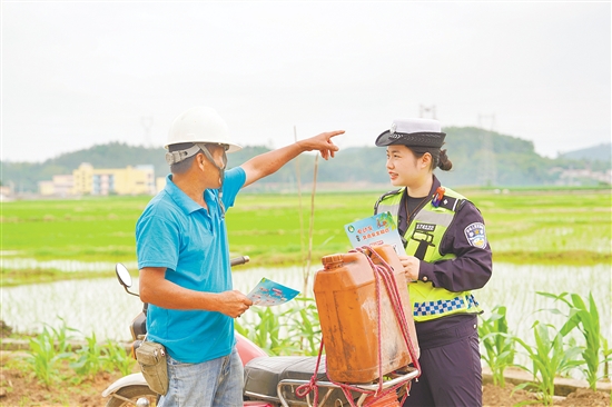 民警向农户派发交通安全宣传单。