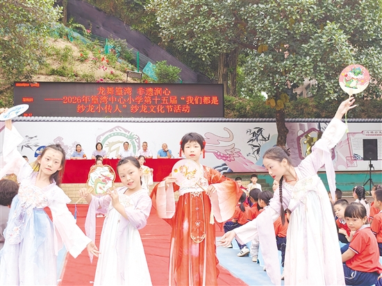 学生们身穿汉服，展示含有龙元素的扇子。