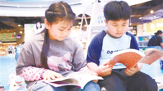 蓬江区里仁小学两名学生周末到书店读书。