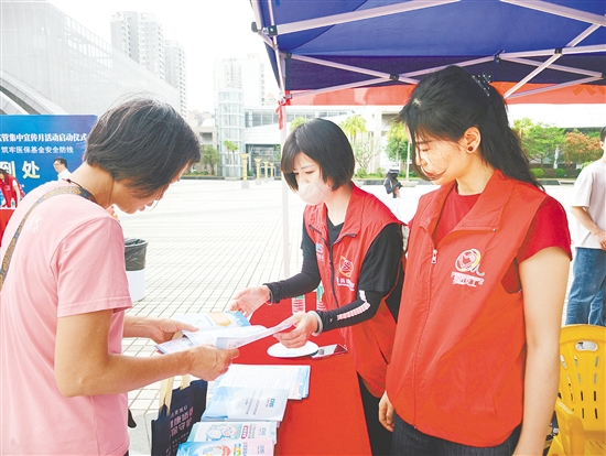 医保工作人员向市民介绍医保待遇。