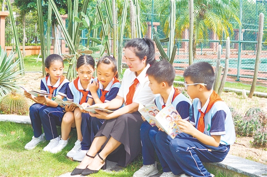在台山市新宁小学，老师与学生们围坐校园一隅，共享阅读的美好时光。