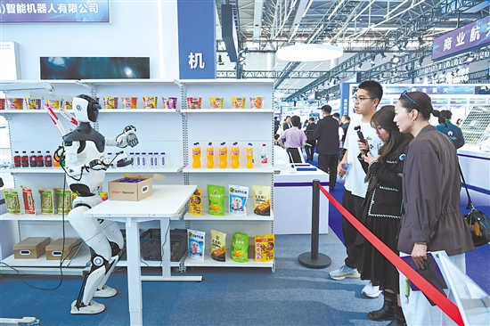 图为当日，观众在第四届科交会上观看一款人形机器人。