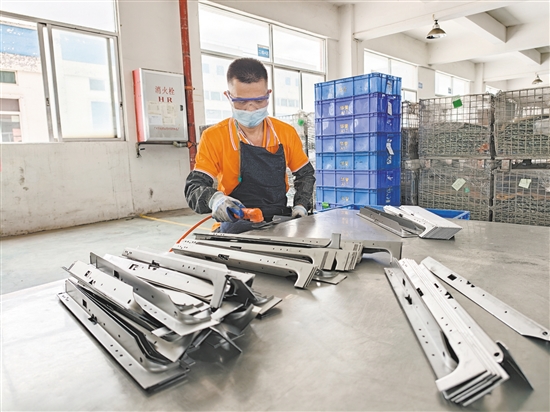 在江门市华誉制造有限公司的生产车间,52岁的残疾人员工黄日道在认真打磨零部件。 在江门市华誉制造有限公司的生产车间,52岁的残疾人员工黄日道在认真打磨零部件。