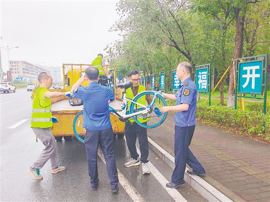 执法人员清理违停共享单车。