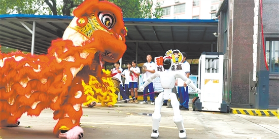 江门市广德实验学校送考仪式上，醒狮与机器人“共舞”。