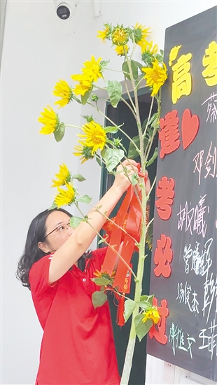 在江海区礼乐中学考点，该校高三（2）班班主任陈老师特地带来3株将近2米高的向日葵，祝福考生“一举夺魁”。