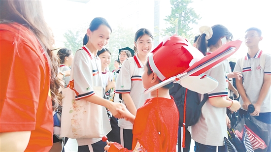 景贤中学考点，该校小学部四年级学生化身“小状元”，为学长学姐加油。