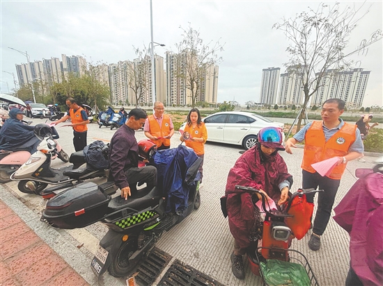 义工家长向学校周边群众派发道路交通安全宣传单。