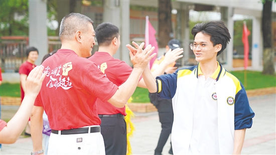 高考前，老师与学生击掌鼓劲。