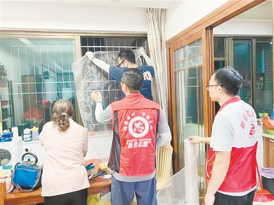 南湖湾小区红色志愿服务队为居民安装防蚊纱网。