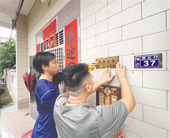 工作人员认真更换光荣牌。
