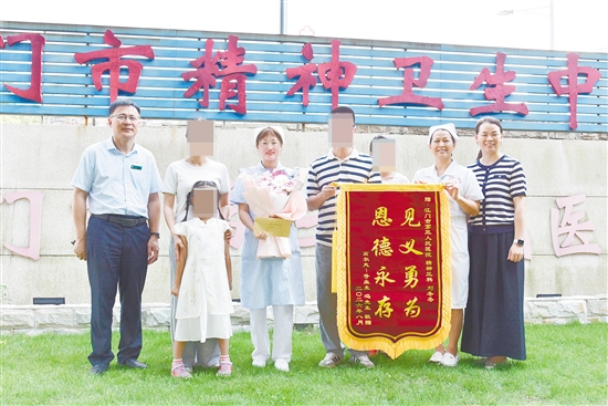 经过多方打听，被救女童父母手捧鲜花、锦旗，来到医院，向刘冬冬（右五）致谢。