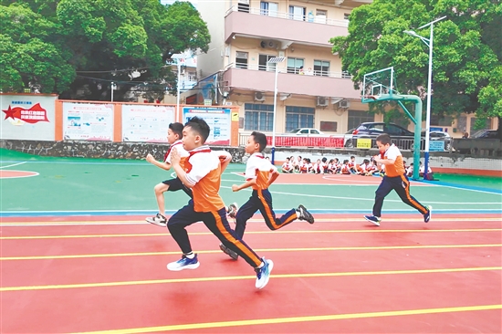 越塘小学学生在崭新的塑胶跑道上奔跑。