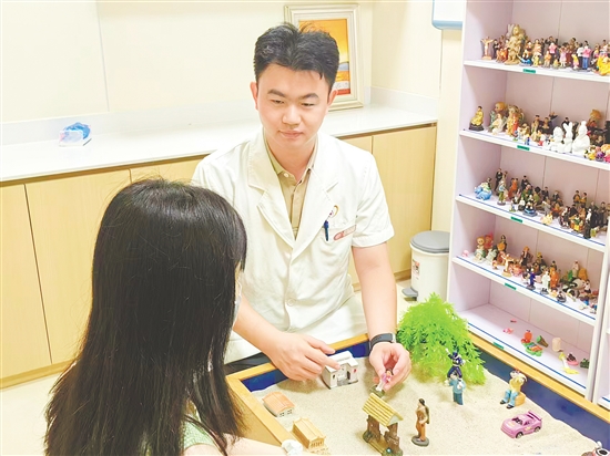心理科医生为共情疲劳的市民进行沙盘治疗。